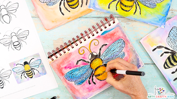 Image showing hands drawing stripes onto the last segment of the bees body.