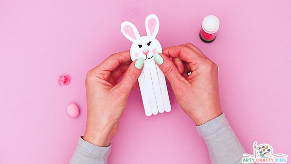 Image showing hands glueing the head onto the Popsicle stick body.