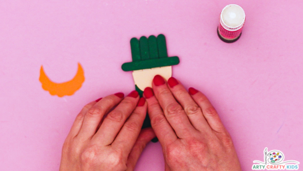 Image showing hands gluing the face onto the popsicle stick.