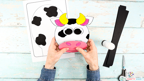 Image showing hands glueing a mouth onto the cow's head.