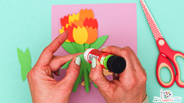 Image showing hands applying glue to one of the tulip's leaves.