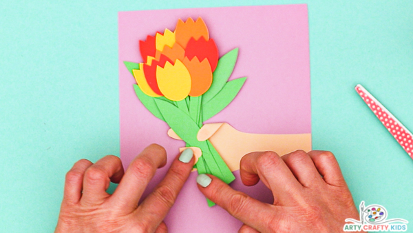 Image showing hands folding the unstuck fingertips around the bouquet. 