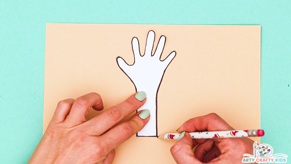 Image showing a hand tracing around a hand and arm from the featured printable template.
