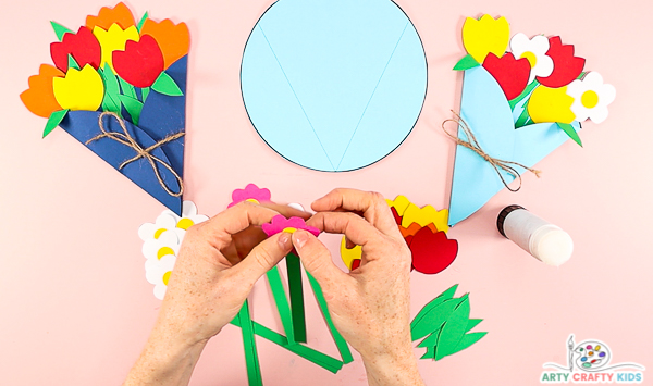 Image showing hands gluing a pink flower head onto a stem.