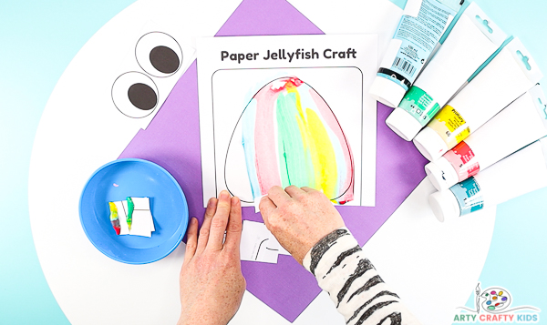 Image showing hands filling the entire jellyfish shape with scraped paper.