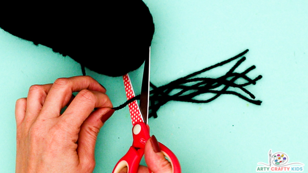 Image showing hands cutting a piece of yarn into the small strips.