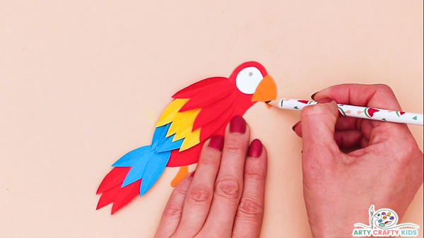 Image showing a hand drawing a smile on the beak with a pencil.