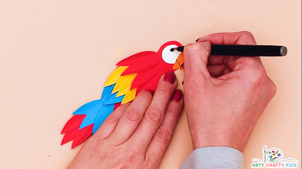 Image showing a hand tracing the smile and pupil with a fine tipped marker pen.