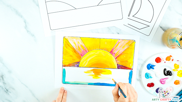 Step 7: Image showing hands painting a yellow and orange reflection into the white space.