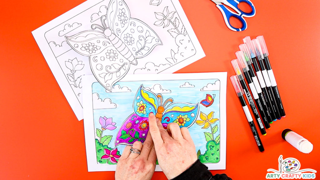 Image showing hands gluing the butterfly to the background to complete the butterfly craft.