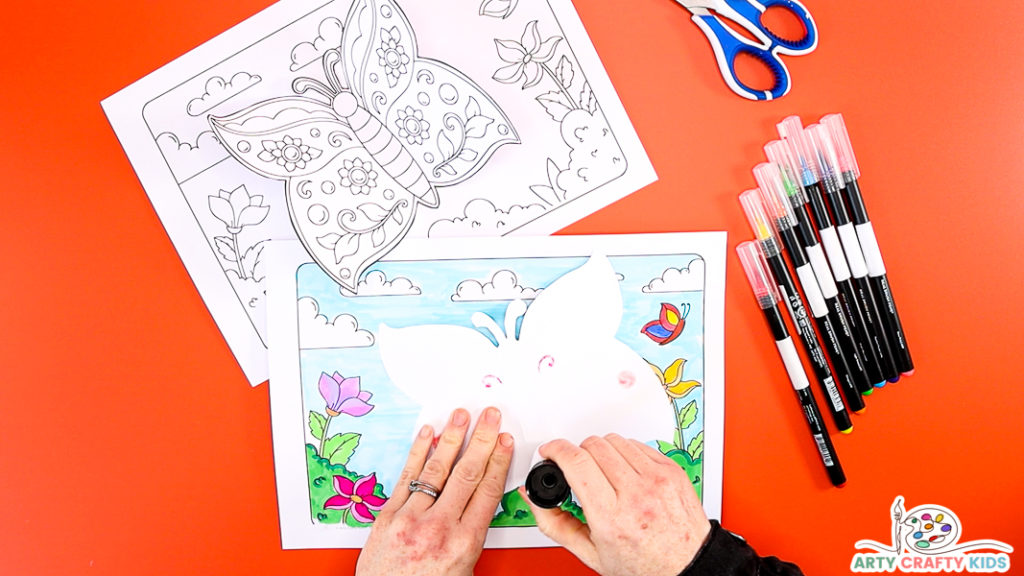 Image showing hands applying glue to the back of the butterfly.