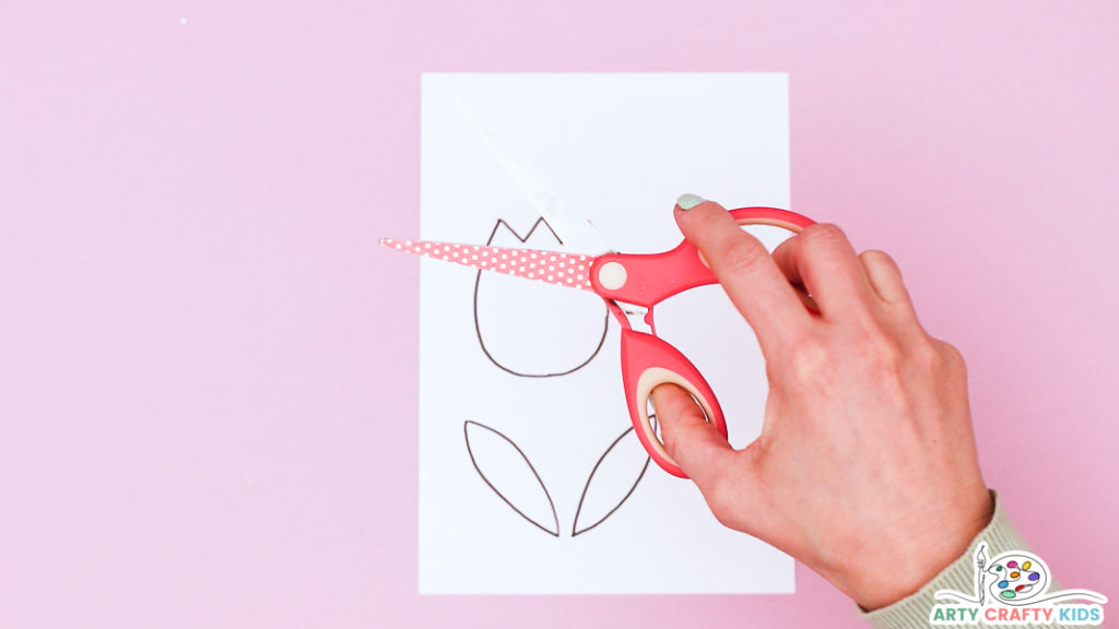 Image showing hands above the tulip template with a pair of scissors.