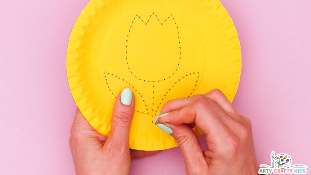 Image showing a hand piercing holes with a needle to a create a stem for the tulip.