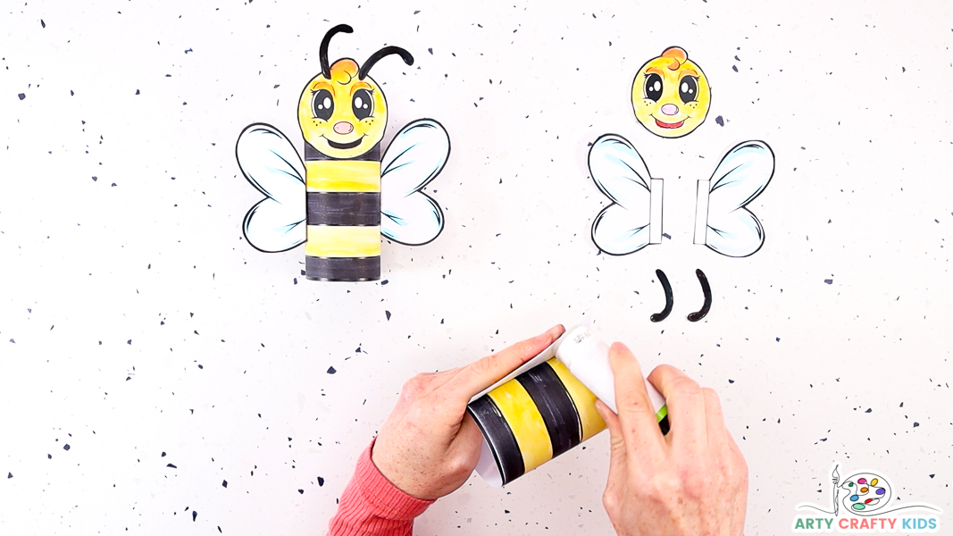 Image featuring a hand rolling paper to make a tube for the bees body.