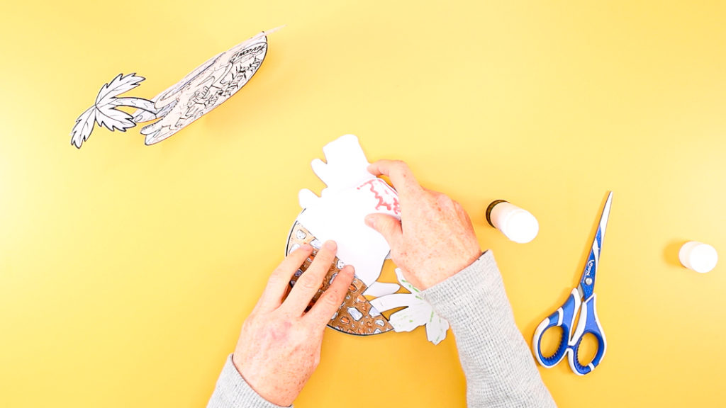 Image featuring hands affixing the volcano piece onto the back of the card.