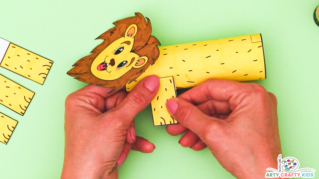 Image featuring a hand affixing one of the lion's legs onto the body of the lion.