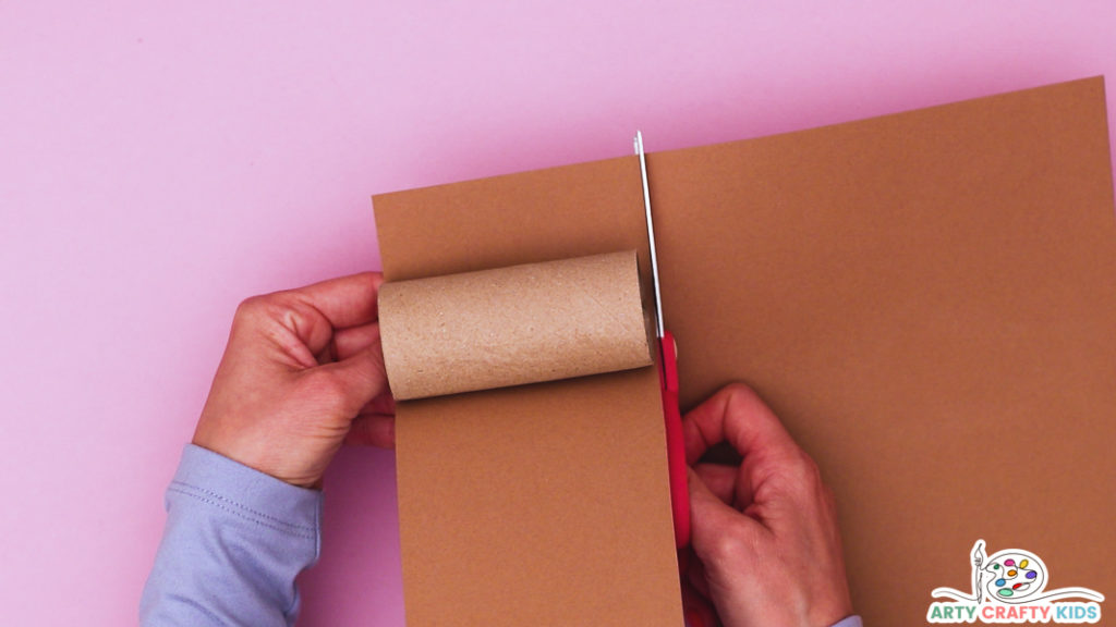 Image featuring a hand cutting a strip of brown paper to wrap around the paper roll.
