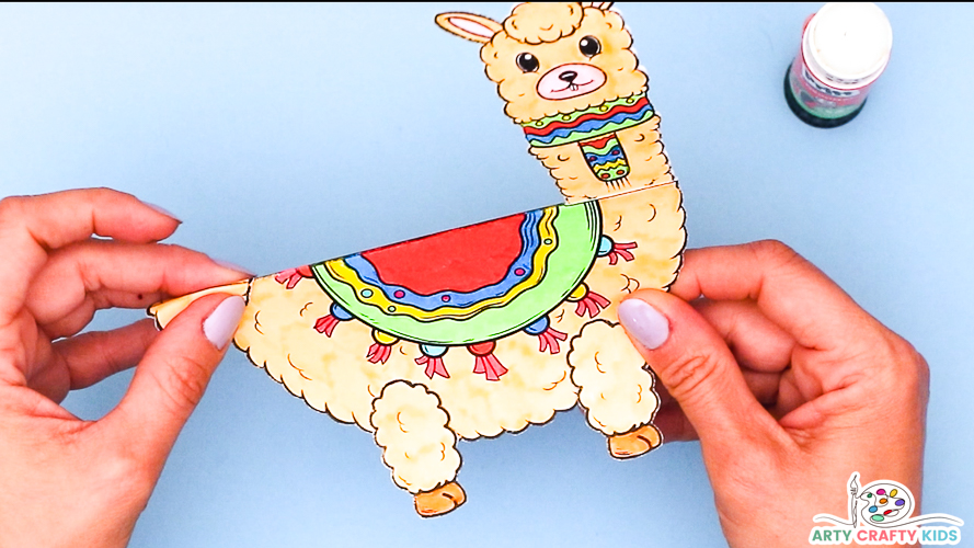 Image of a hand glueing the final piece to the llama's body.