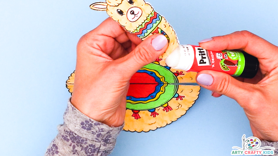 Image of a hand applying glue to the neck area of the llama.