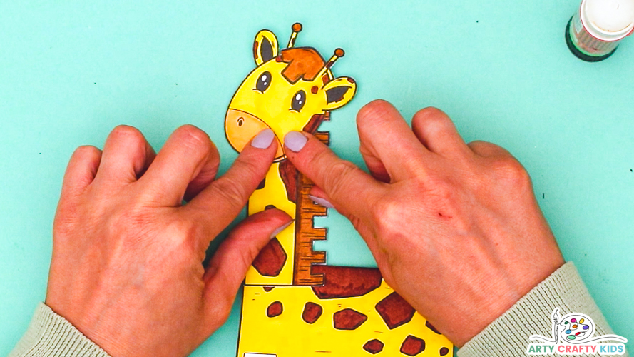 Image a pair of hands affixing the giraffe's head to the neck element.