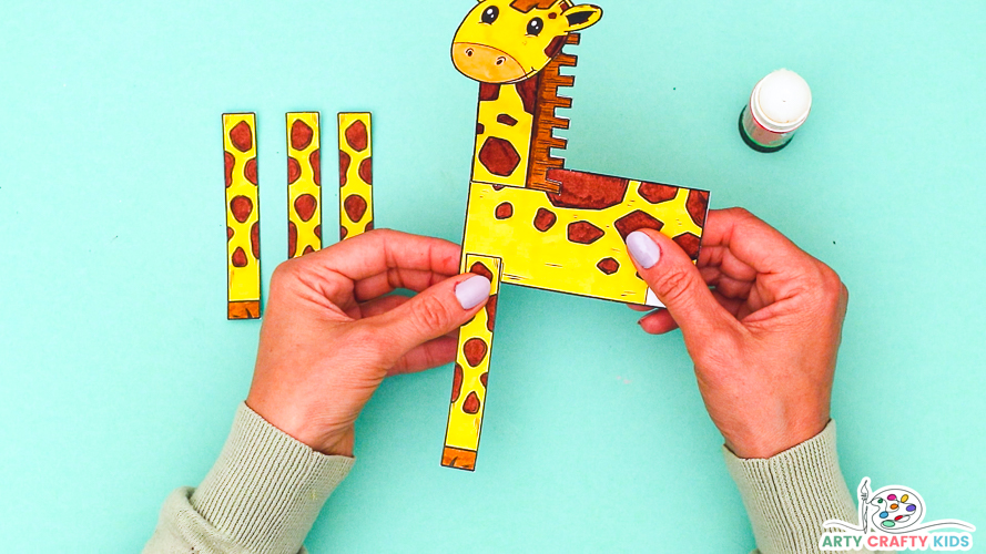 Image featuring hands affixing legs to the giraffe craft.