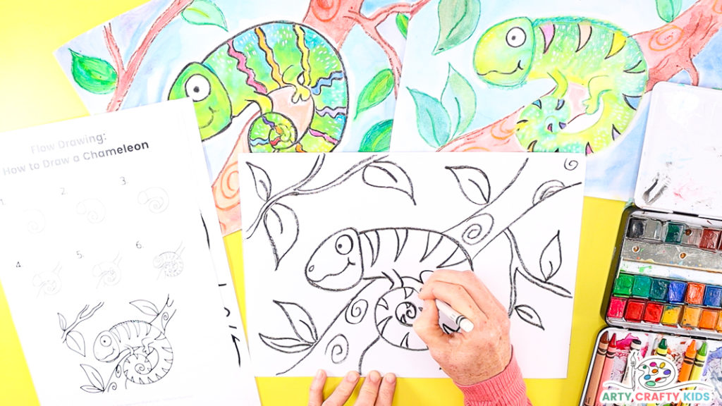 Image featuring a hand outline the chameleon with a white crayon - preparing the drawing for the addition of watercolor.