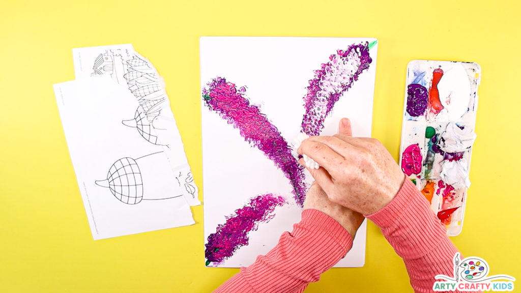 Image of a hand printing with a cluster of q-tips to add a f