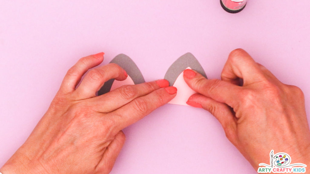 Image of a hand glueing the inner and outer ear elements together.