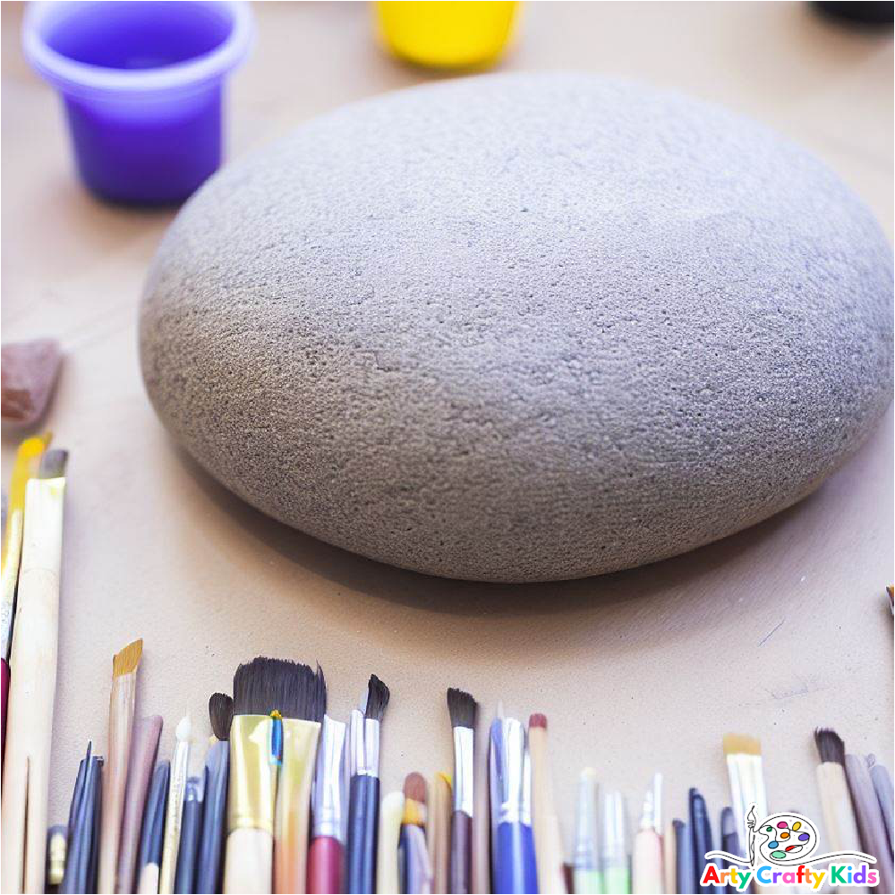 Image featuring a large clean grey rock surrounded by paintbrush and paint.