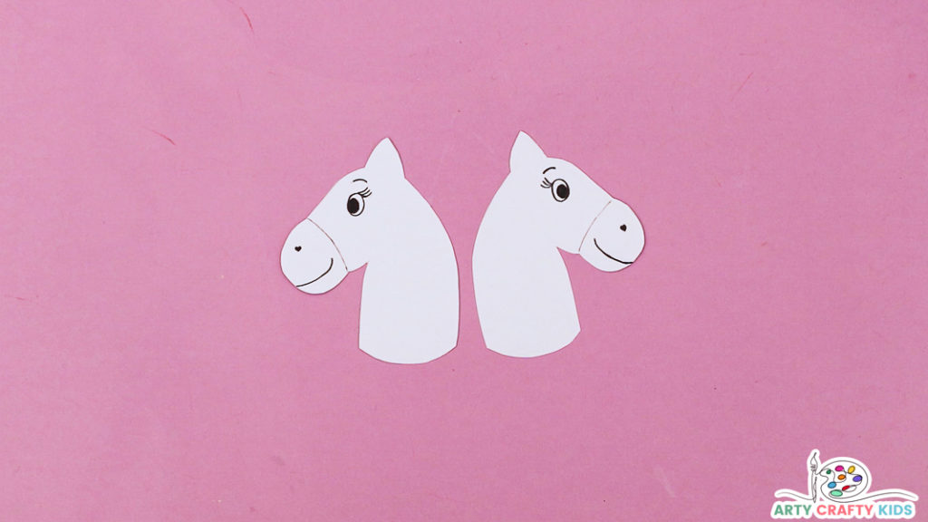Image featuring a pair white unicorn heads with a hand drawn smile and eyes.