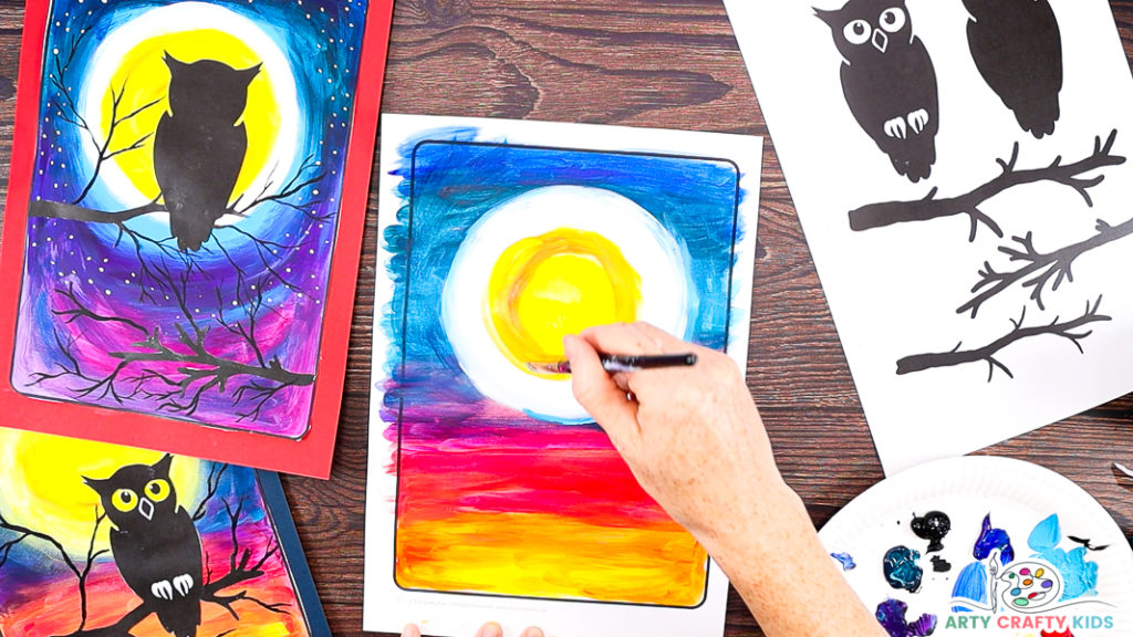 Image of a hand painting the center of the moon a bright yellow and gradually blending into the white outline.