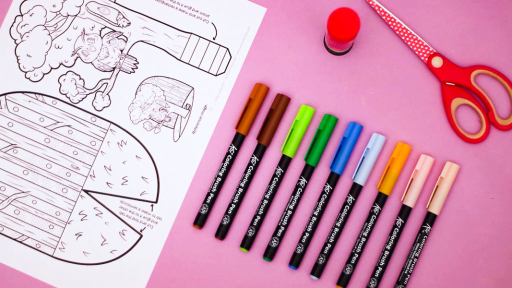 Image featuring the pop-up owl coloring craft template and materials, including pens, a pair of scissors and a glue stick.