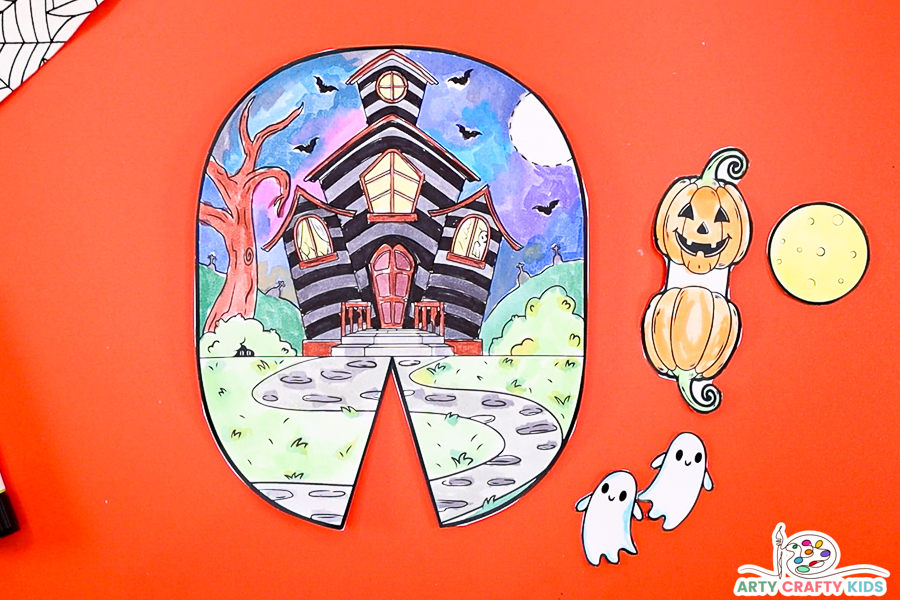 Step 2: Image features a cut out haunted house and ghost, pumpkin and moon elements. 