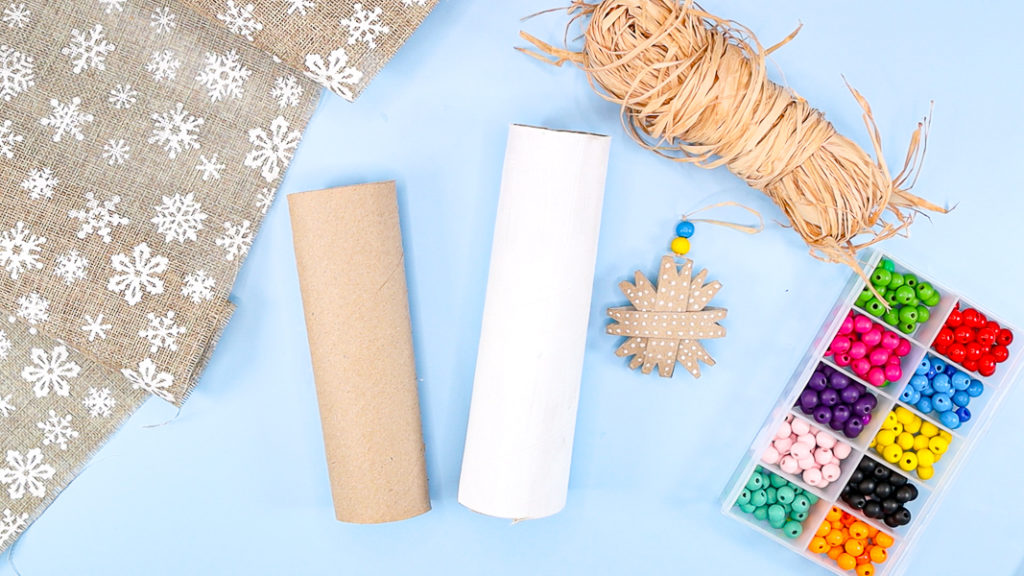 Image showing paper rolls, a roll of craft straw, colorful wooden beads and a pre-made rustic paper roll snowflake ornament craft.