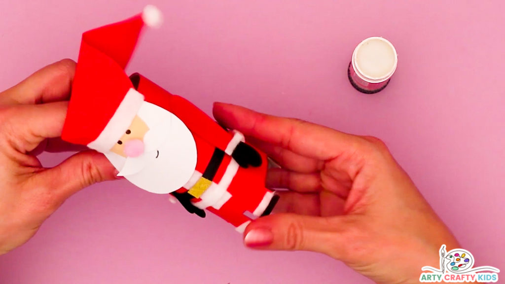 Image showing a hand affixing the arms onto the paper roll Santa.