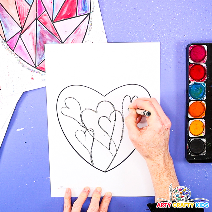 Image of a hand drawing heart shapes within a heart outline.