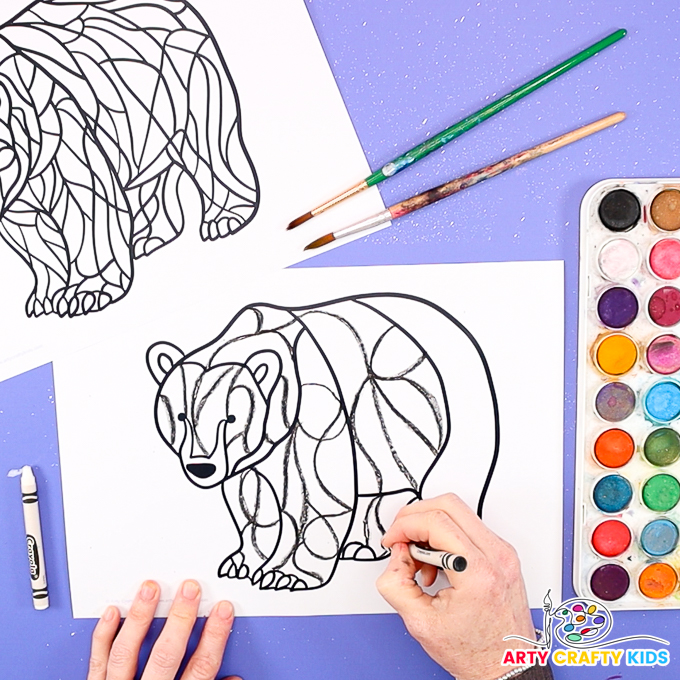 Image of a hand drawing lines with a black crayon to create abstract line art within the body segment of the polar bear template.