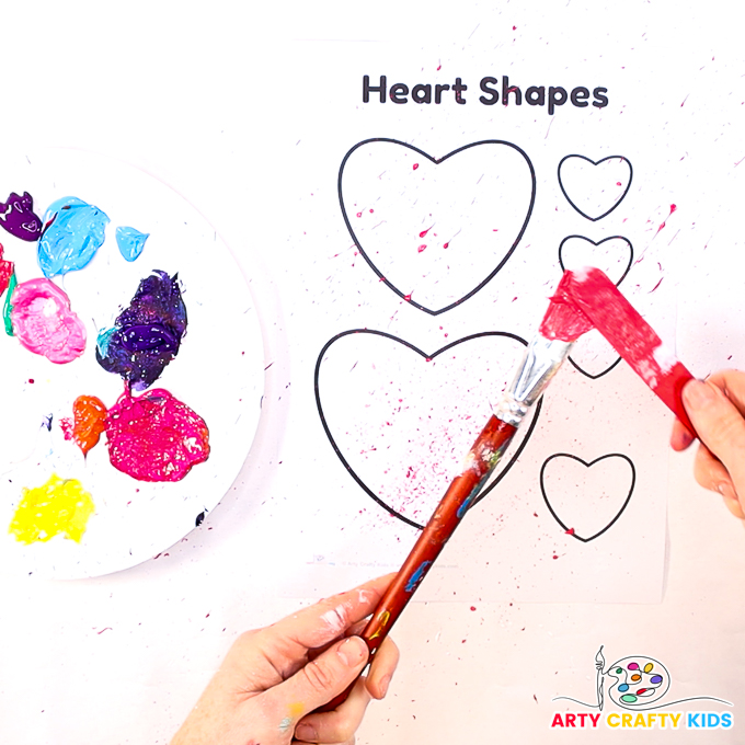 Image featuring a hand splatting paint over the heart art template.