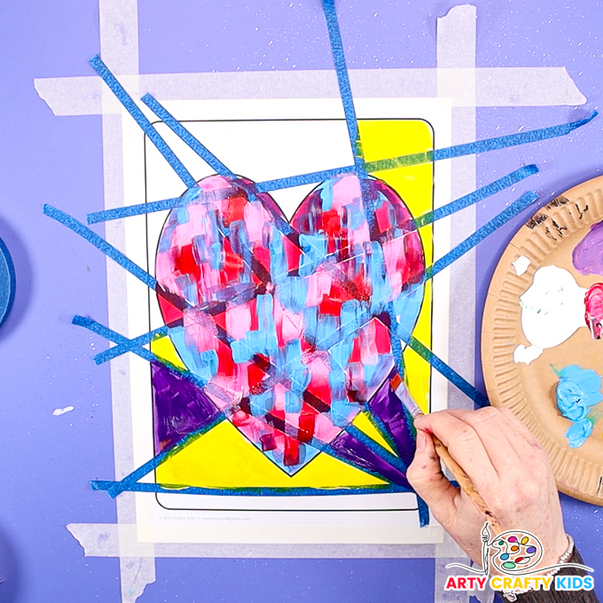 Image of a hand painting the surrounding space around the heart yellow and purple.