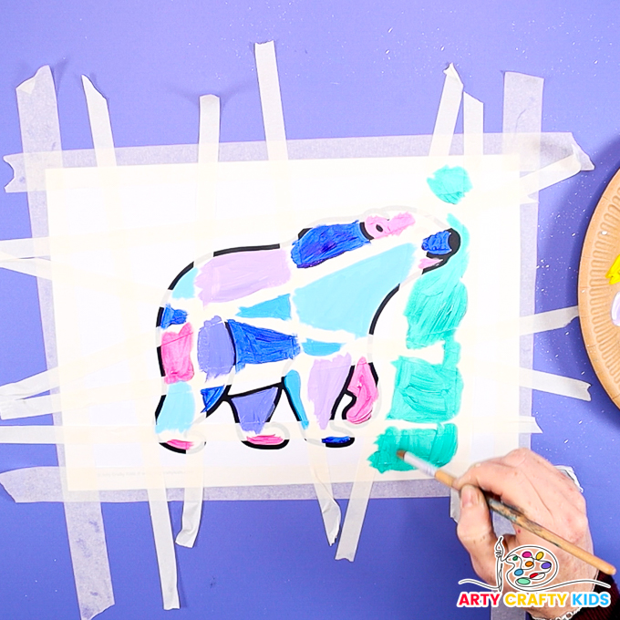 Image of a hand painting the polar bear in cool hues.