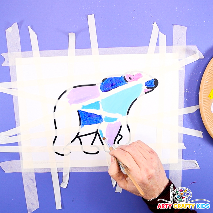 Image of a hand painting the polar bear in cool hues.