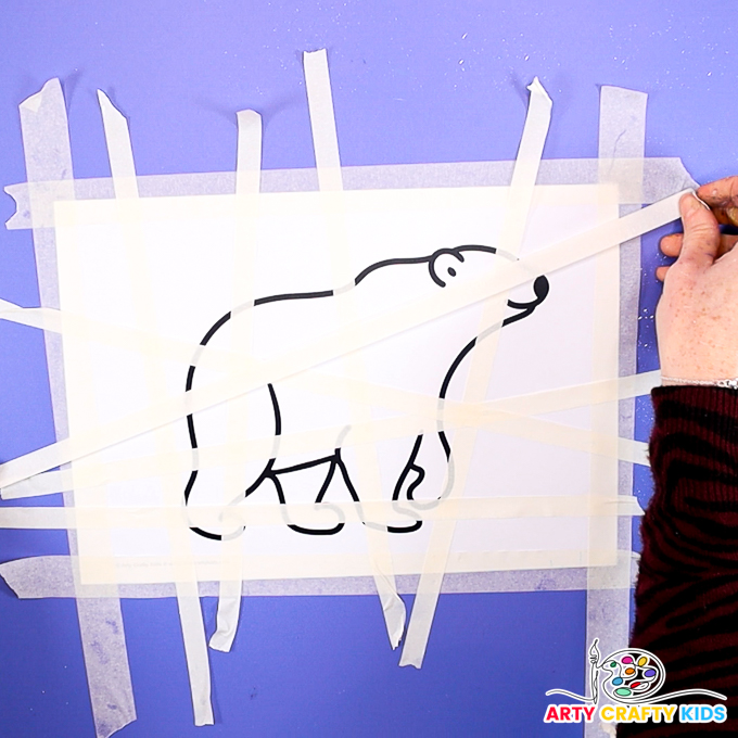 Image of a hand applying tape across the polar bear template.