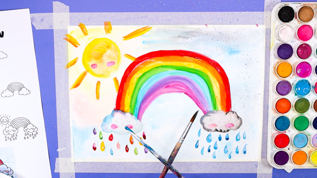 Image of a hand splattering paint across the watercolor rainbow painting.