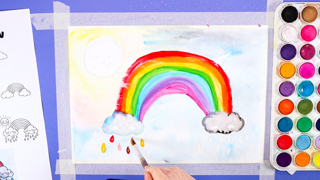 Image of a hand painting the raindrops in rainbow colors.