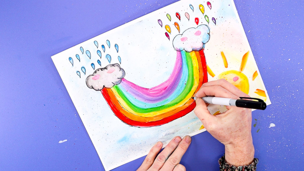 Image of a hand outline the rainbow with a black fine tipped pen.