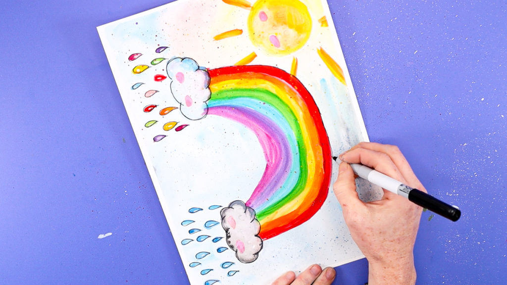 Image of a hand outline the rainbow with a black fine tipped pen.