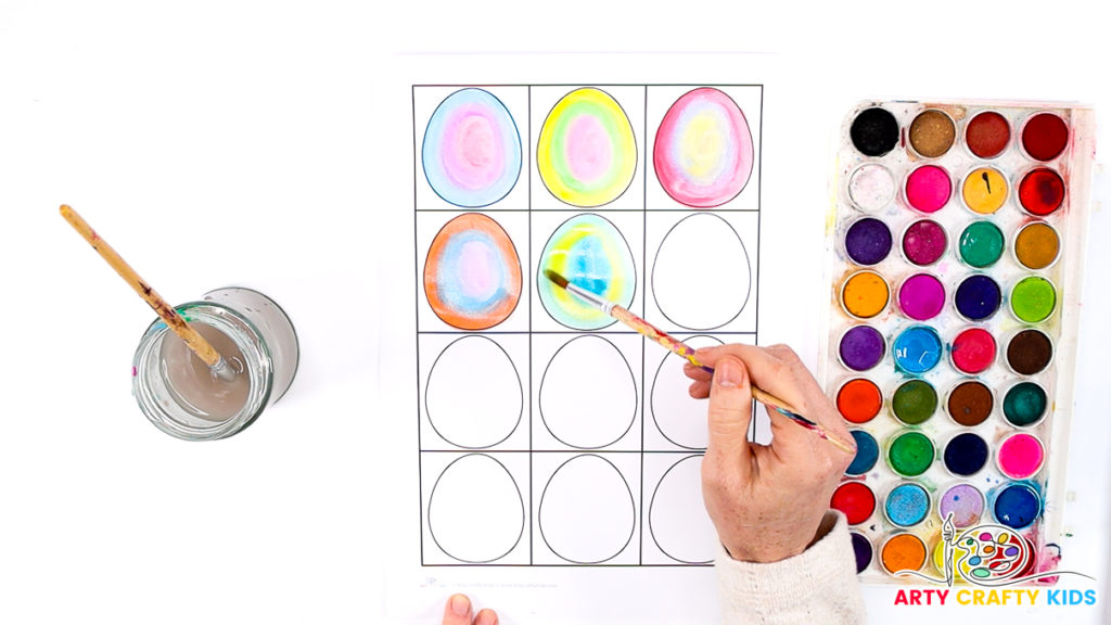 Image of hand painting the Easter eggs in the style of Kandinsky - the eggs are filled with lots of vibrant watercolors.