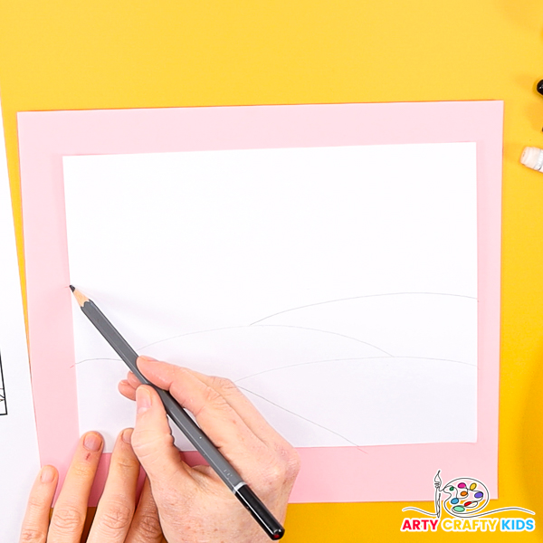 Image of a hand sketching a landscape with a pencil.