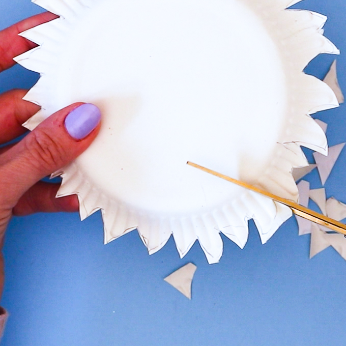 Image of a hand using scissors to shape the dog.