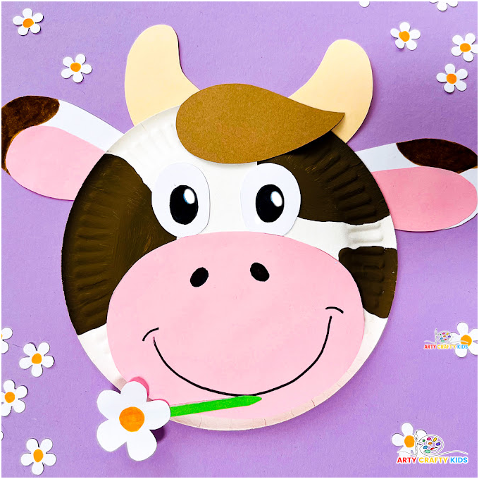 Completed paper plate cow craft featuring a cute cow with brown spots, big eyes and a smile, chewing on a daisy. Lots of preschool appeal!